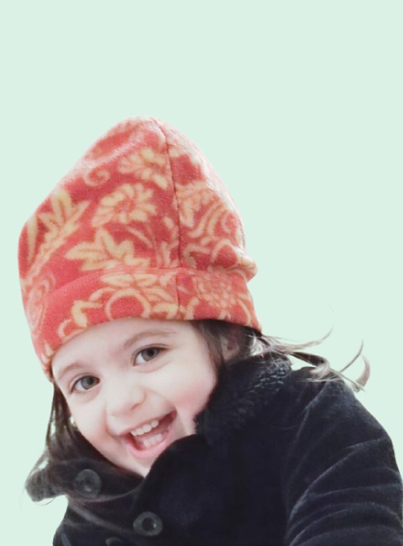 Kathy's granddaughter, laughing in a red winter hat